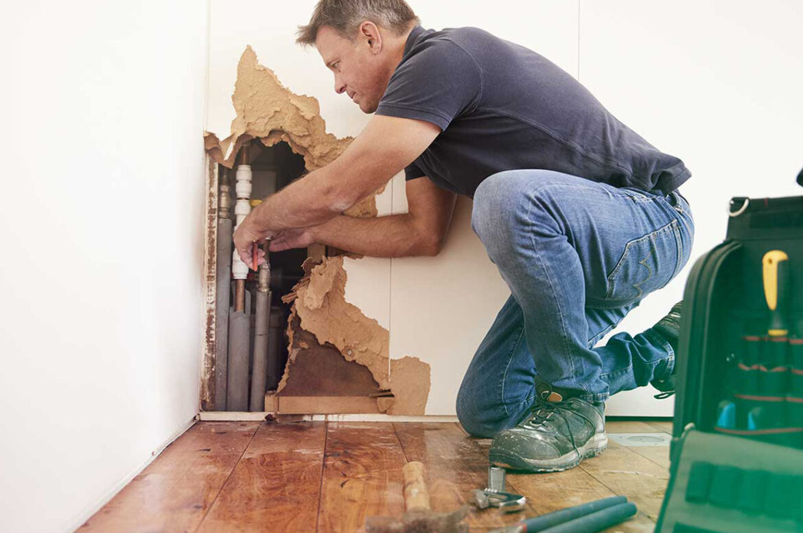 Restoration, remediation and cleaning employee fixing dry wall in a home